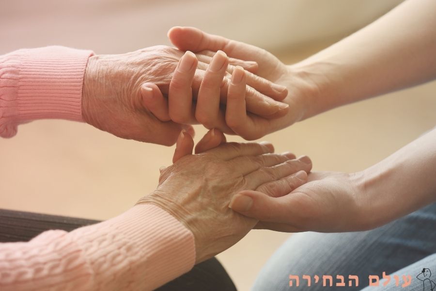 קשישה וצעירה מחזיקות ידיים